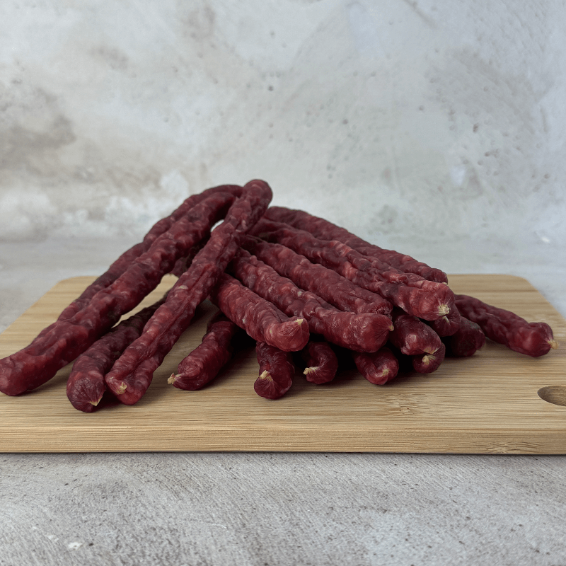 OUBAAS Salami Sticks - 500g arranged on a wooden cutting board, showcasing rich, smoky flavor.