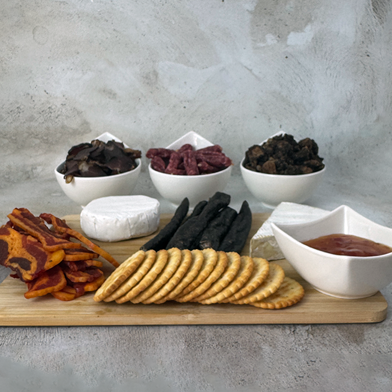 Biltong Braai Box hamper with biltong, droëwors, salami bites, nuggets and honey glazed bacon on serving board