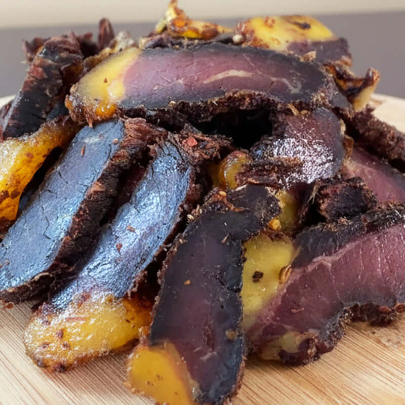 Close-up view of premium geelvet biltong showing the natural golden fat layer with a soft sheen, highlighting the rich texture and traditional air-dried finish.