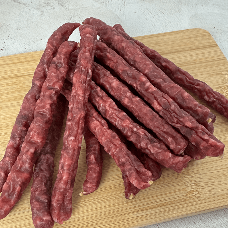OUUBAAS Salami Sticks - 500g arranged on a wooden board for snacking, showcasing rich color and texture.
