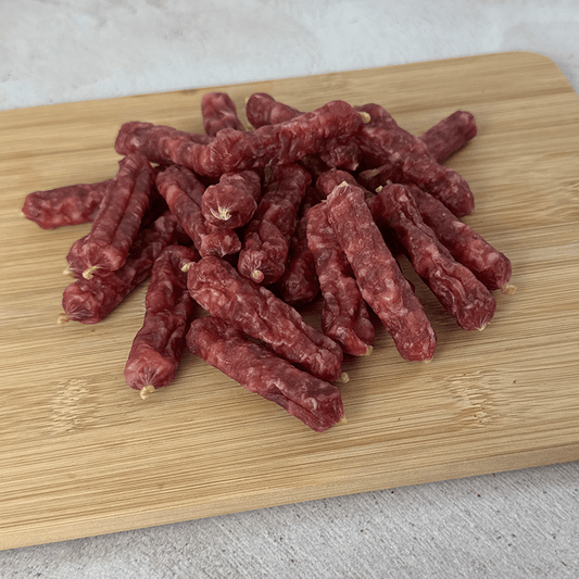 salami bites on a wooden cutting board with a light background