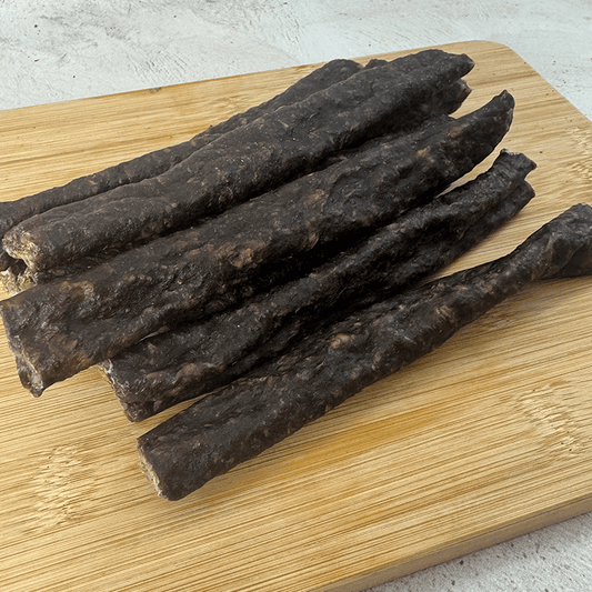 a pile of springbok droewors laying on a wood board on an angle shot of the product